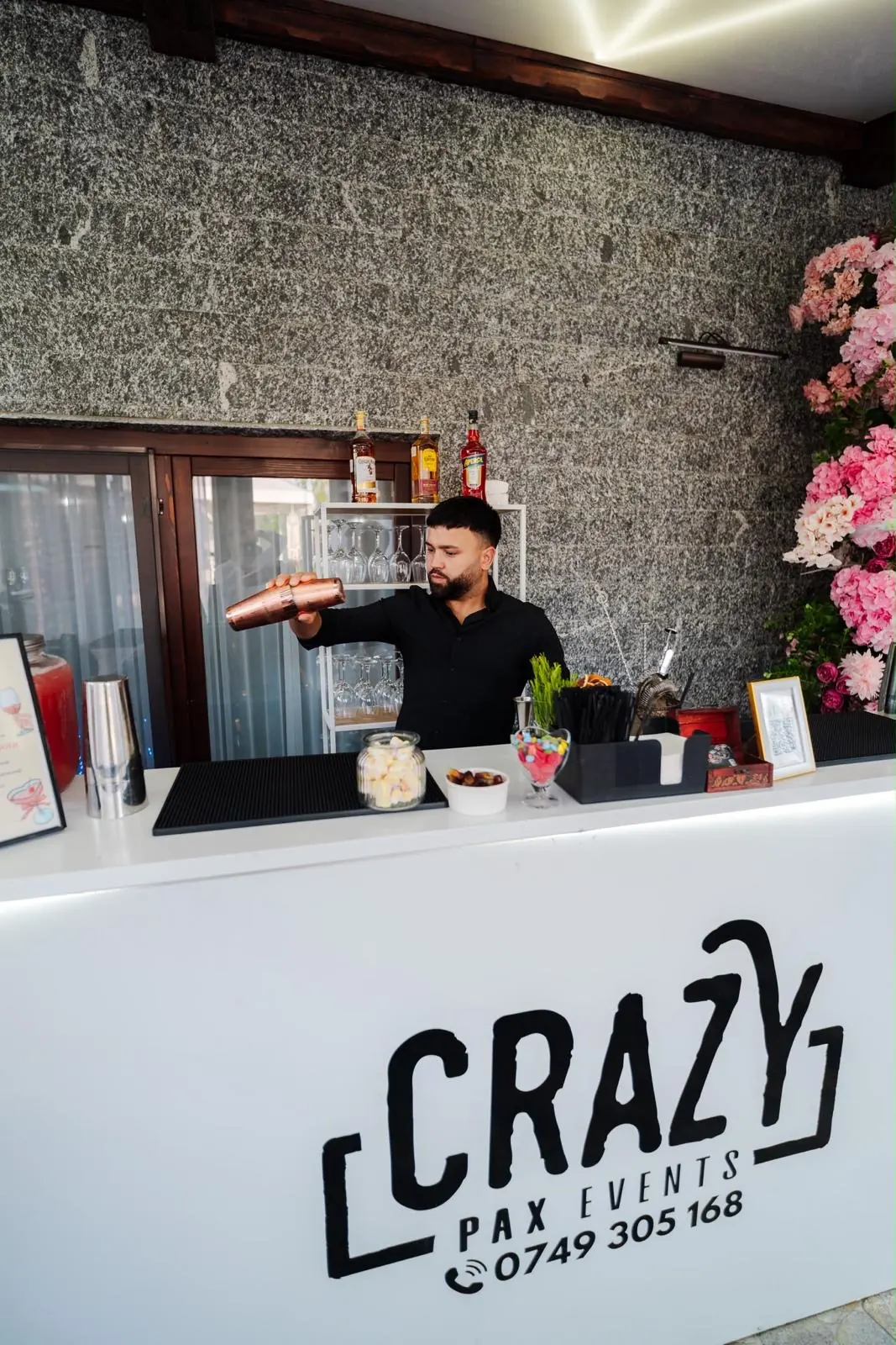 Barman Crazy Pax pregătind shoturi la barul alb