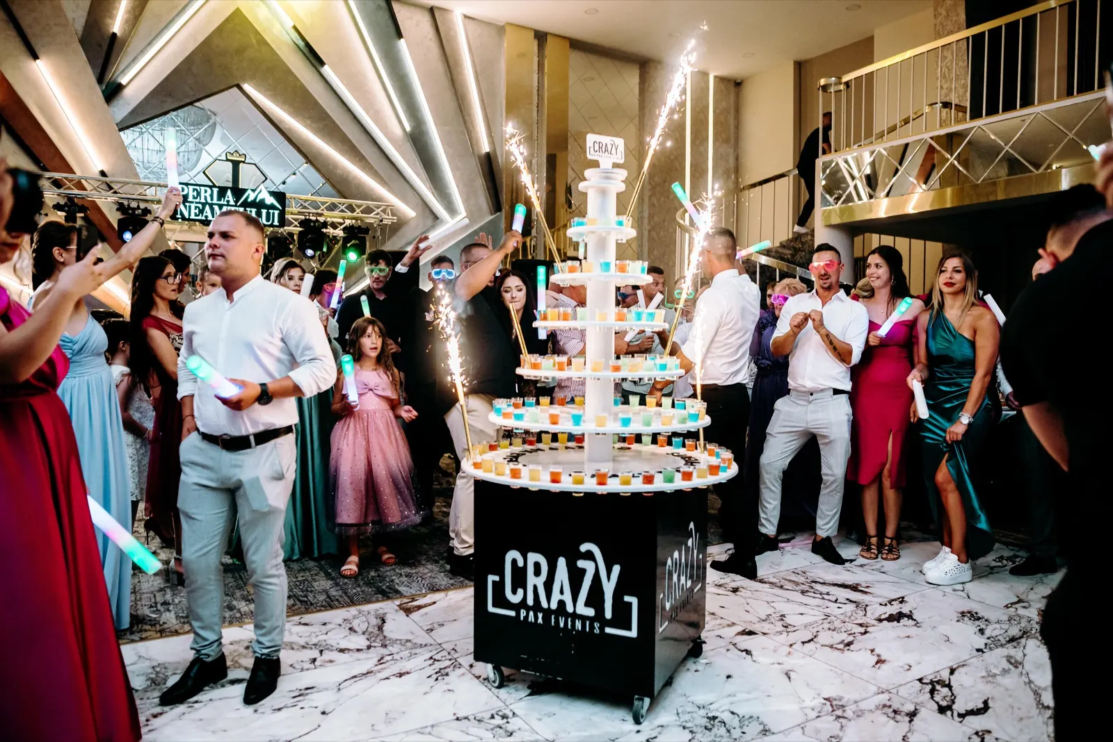 Invitați adunați în jurul tortului de shoturi Crazy Pax